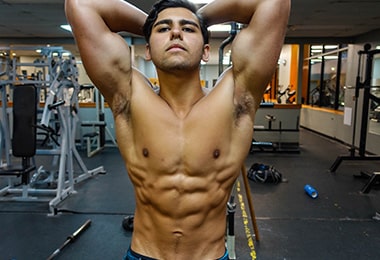 Aseel Posing in a Body building pose infront of Gym
